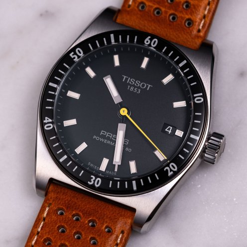 black-dial Tissot PR516 Powermatic 80 on leather strap, flat lay